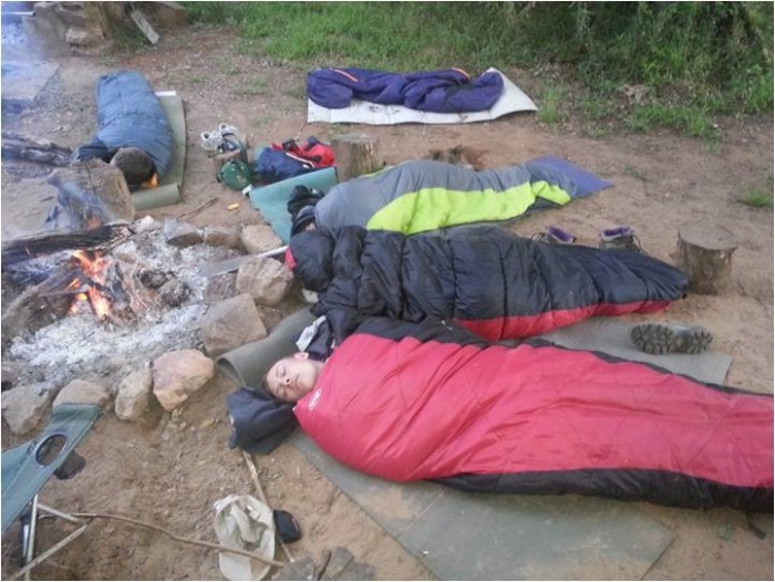 Tired after a hard days work, the volunteers have a snooze around the campfire