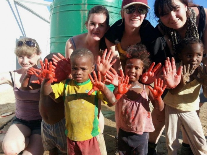 Volunteers and children show off their painting hands