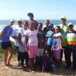 A volunteer and school children down at the beach