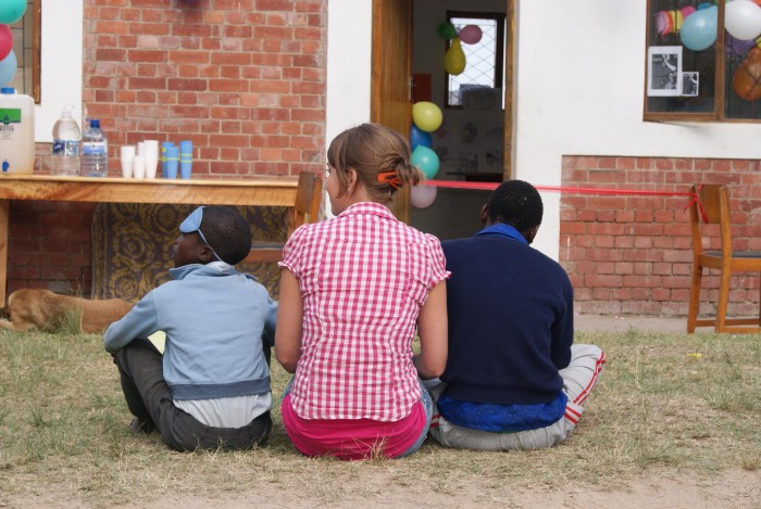 A volunteer sitting with two local children