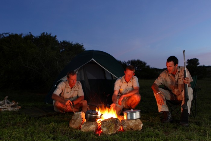 Game rangers gather round a campfire