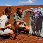A Shamwari game ranger shows a volunteer her shots on the buffalo board