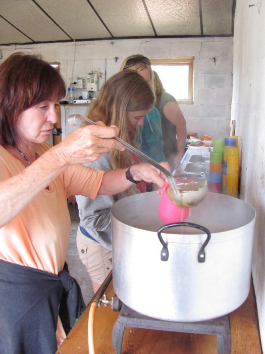 Volunteers pour soup into bowls