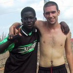 A volunteer and football player pose for a picture
