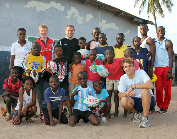 A group picture of volunteers and students learning rugby