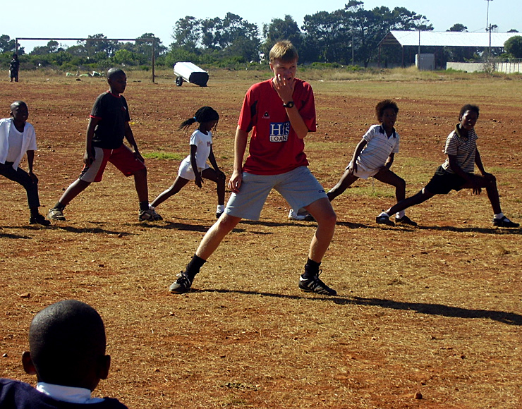 A volunteer shows some of the local youths how to stretch